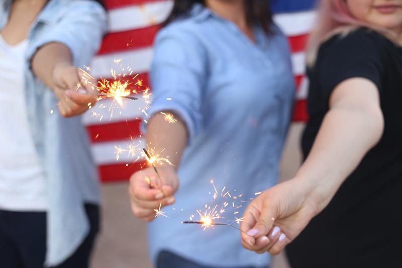 People having fun at an American House Party with the U.S. flag behind them